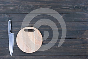 Kitchen knife and wooden round empty cutting board