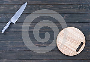 Kitchen knife and wooden round empty cutting board