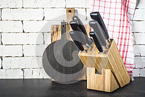 Kitchen knives set, cutting boards and towel on the kitchen tabl