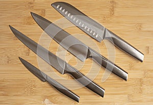 Kitchen knives set of steel on wooden table. High angle view