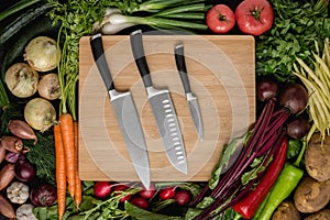 Kitchen Knives Set on Wood Cutting Board with Fresh Vegetables
