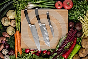 Kitchen Knives Set on Wood Cutting Board with Fresh Vegetables photo