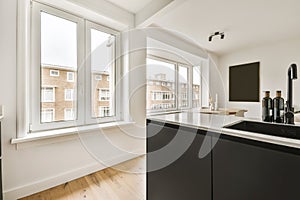 a kitchen with a large window and a black counter