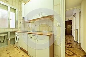 kitchen with light furniture in an apartment with garish stoneware floors