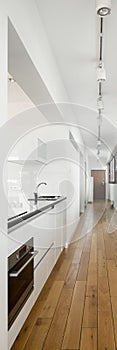 Kitchen in long apartment corridor  vertical panorama