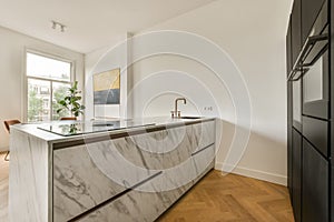 a kitchen with marble counter tops and a window