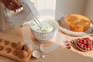Kitchen mixer whips cream to make sponge cake or red velvet cake photo