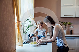 Kitchen mom son wash fruits and vegetables