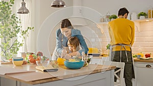 In Kitchen: Mother and Cute Little Daughter Cooking Together Healthy Dinner. Mom Teaches Little Gi