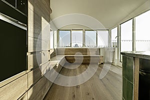 Kitchen with oak wood furniture and perimeter bench with drawers under a large window