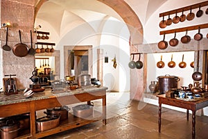 Kitchen with old cooper utensils, retro furniture in vintage style rural home. Traditional cottage pots for cooking