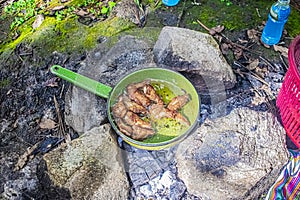 Kitchen pan on stones and chicken wings with cajola fire photo