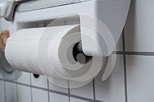 A kitchen paper towel roll hanging on the wall in the kitchen