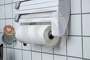 A kitchen paper towel roll hanging on the wall in the kitchen