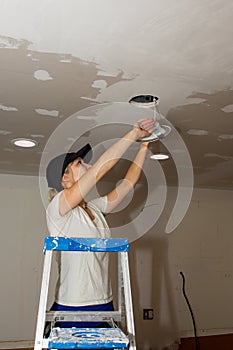 Kitchen Remodel Young Woman Installing Ceiling Light