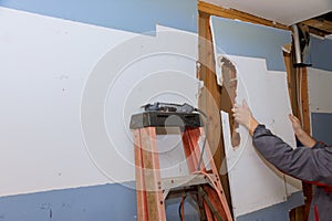 Kitchen renovation in progress with removed old sheetrock preparing for new cabinet installation