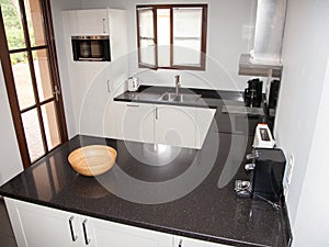 Kitchen room interior with white cabinets, kitchen island and granite counter tops