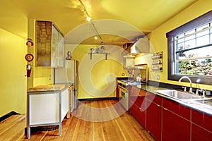 Kitchen room interior with yellow walls and red cabinets.