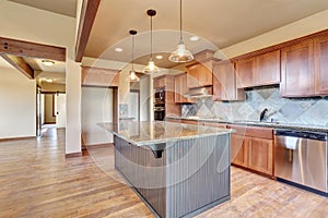 Kitchen room with wooden cabinets, island and granite counter top