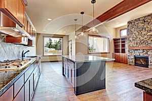 Kitchen room with wooden cabinets, island and granite counter top