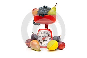 Kitchen scale and fruit isolated on white background