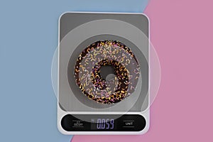 Kitchen scales, cake on a colored background