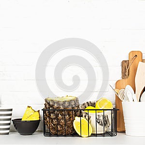 Kitchen shelf lifestyle white background with fresh lemons, pineapple, kitchen tools, appliances, chopping boards