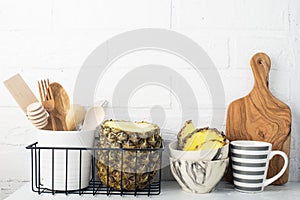 Kitchen shelf lifestyle white background with fresh lemons, pineapple, kitchen tools, appliances, chopping boards