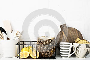Kitchen shelf lifestyle white background with fresh lemons, pineapple, kitchen tools, appliances, chopping boards