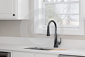 A kitchen sink detail with a black faucet.