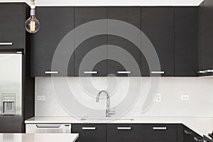 A kitchen sink detail with modern wood cabinets and chrome faucet.