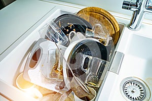 Kitchen sink with dirty dishes and utensils. Mess and sink. Dirty kitchen utensils.