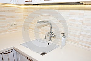 Kitchen sink and faucet. Modern, bright, clean kitchen interior details.