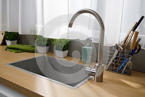 Kitchen sink, faucet and other kitchen utensils.