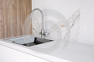 Kitchen sink and faucet on white kitchen