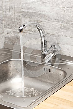 Kitchen sink with running tap water