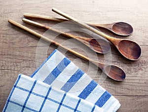 Kitchen still life with cooking spoons and dishcloths on wooden table