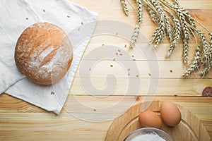Kitchen still life from flour, wheat ears, bread and eggs