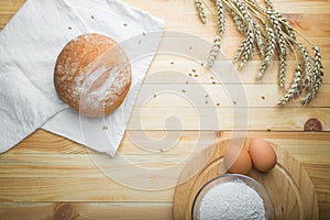 Kitchen still life from flour, wheat ears, bread and eggs