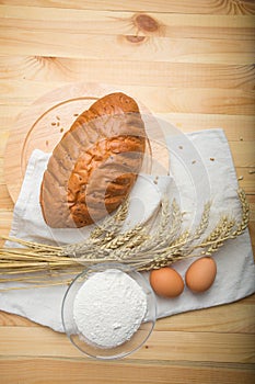 Kitchen still life from flour, wheat ears, bread and eggs