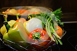 Kitchen still-life. Fresh raw vegetables and a boiling cauldron with appetizing supper meal on the electric stove. Fresh vegetable