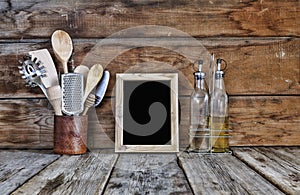 Kitchen still life. Kitchen utensils in a stand near the wooden wall.Kitchen tools, wooden frame with free space for text on a kit