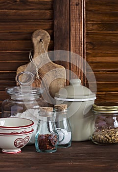 Kitchen still life. Olive chopping board, glass jar with flour, vintage utensils - bowl, Cup, pot and jars of spices and homemade