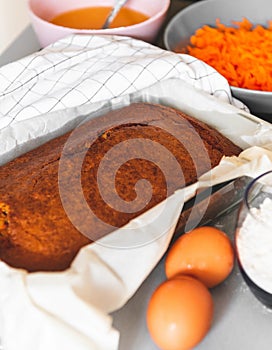 kitchen table with carrot cake and raw ingredients