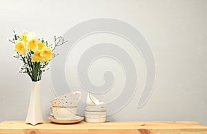 Kitchen table with coffee cups and spring flowers. Simple home kitchen interior, mockup for product design and display, zero waste