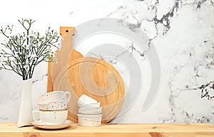 Kitchen table with dishes, cutting boards and spring flowers. Simple home kitchen interior, mockup for product design and display