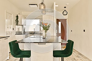 a kitchen with a table and green chairs