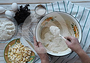 Kitchen table with ingredients for making semolina pie.Hands of an elderly woman kneading dough.Food pastry background.