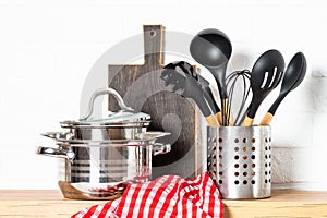 Kitchen table, kitchen utensils, cooking pots at white kitchen.