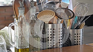 kitchen table.metal stands with cutlery,glass bottles with olive oil and vinegar